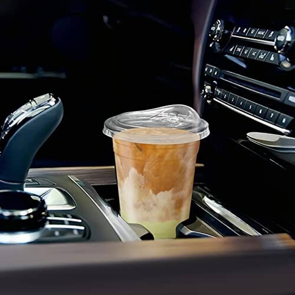 Clear 16 oz iced coffee cup with strawless sip lid placed in vehicle console