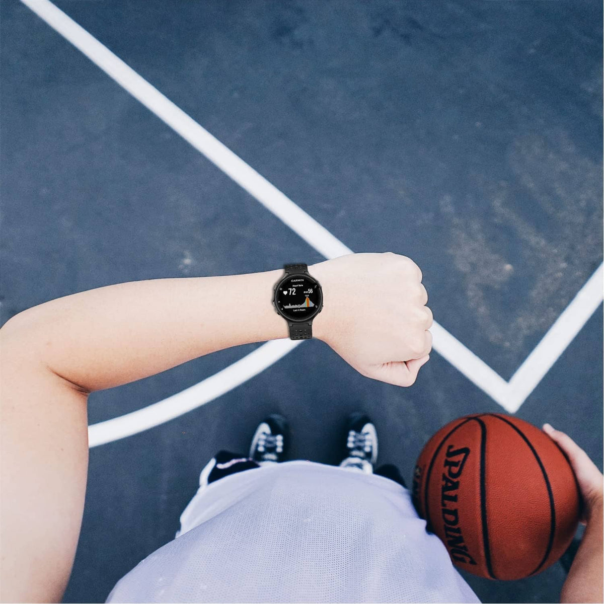 Black perforated smartwatch band on wrist during sports activity