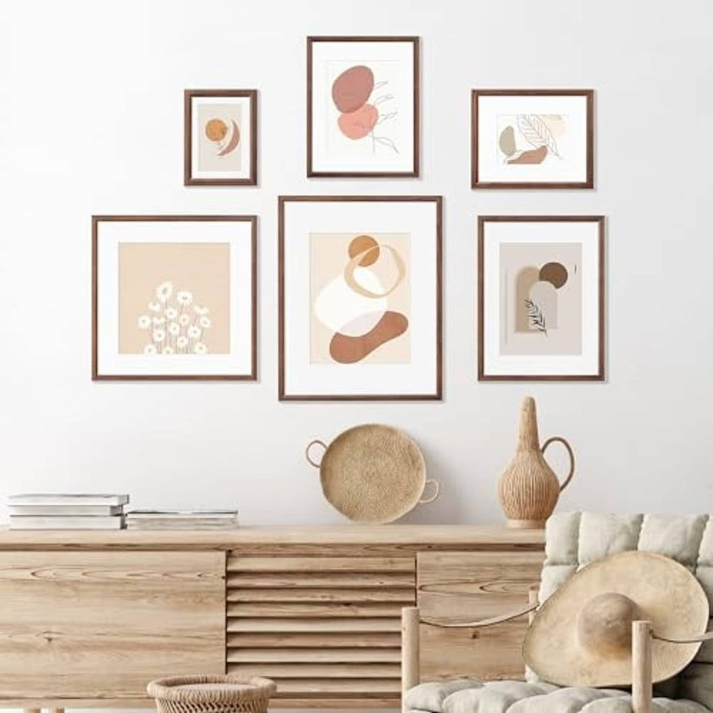 Set of walnut 8x10 picture frames with white mats arranged on a wall