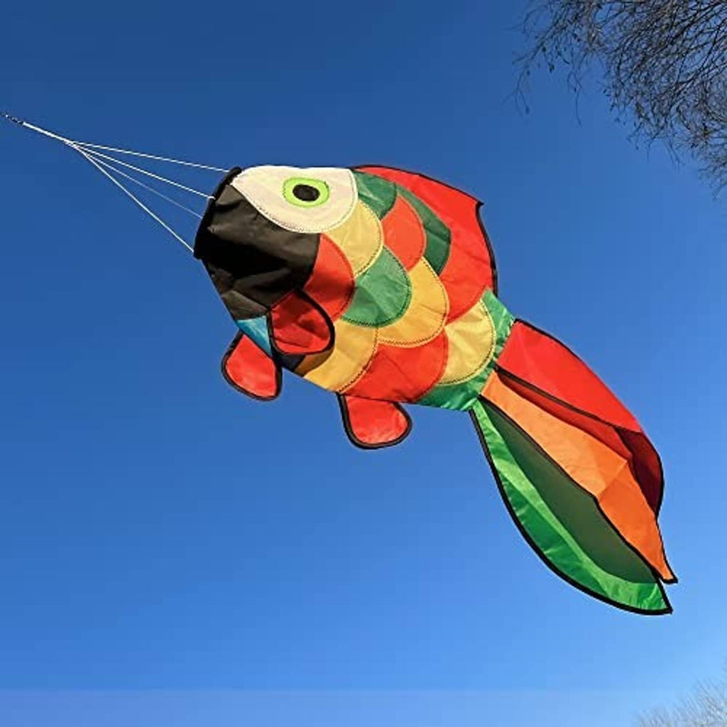 Rainbow fish windsock flying outdoors with green eye, red and yellow fins, and curved tail