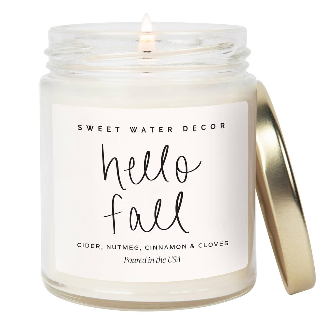 Glass jar candle with 'Hello Fall' label, lit wick, white wax, cider and cinnamon apples scent