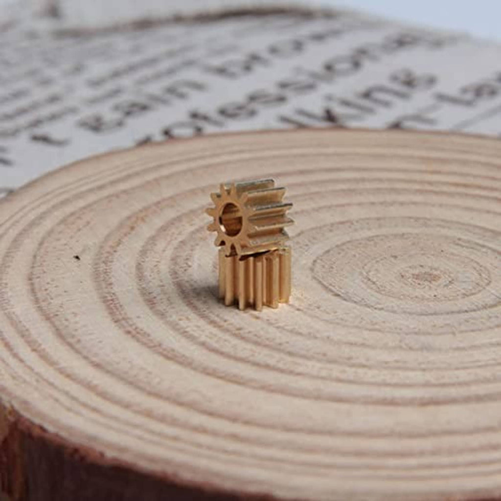 Copper 12-tooth spur gear with 3 mm bore, angled on a wooden slice