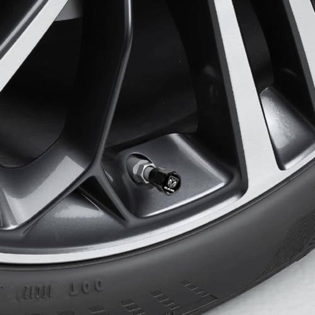 Black octagonal valve stem cap with RAM logo installed on wheel rim