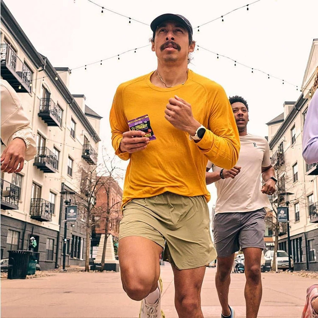 Runner holding a Honey Stinger energy fuel packet outdoors