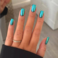 Teal chrome press-on nails, medium short square, glossy mirror finish on a hand