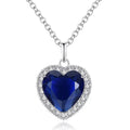 Silver heart pendant necklace with blue faceted gemstone and crystal halo