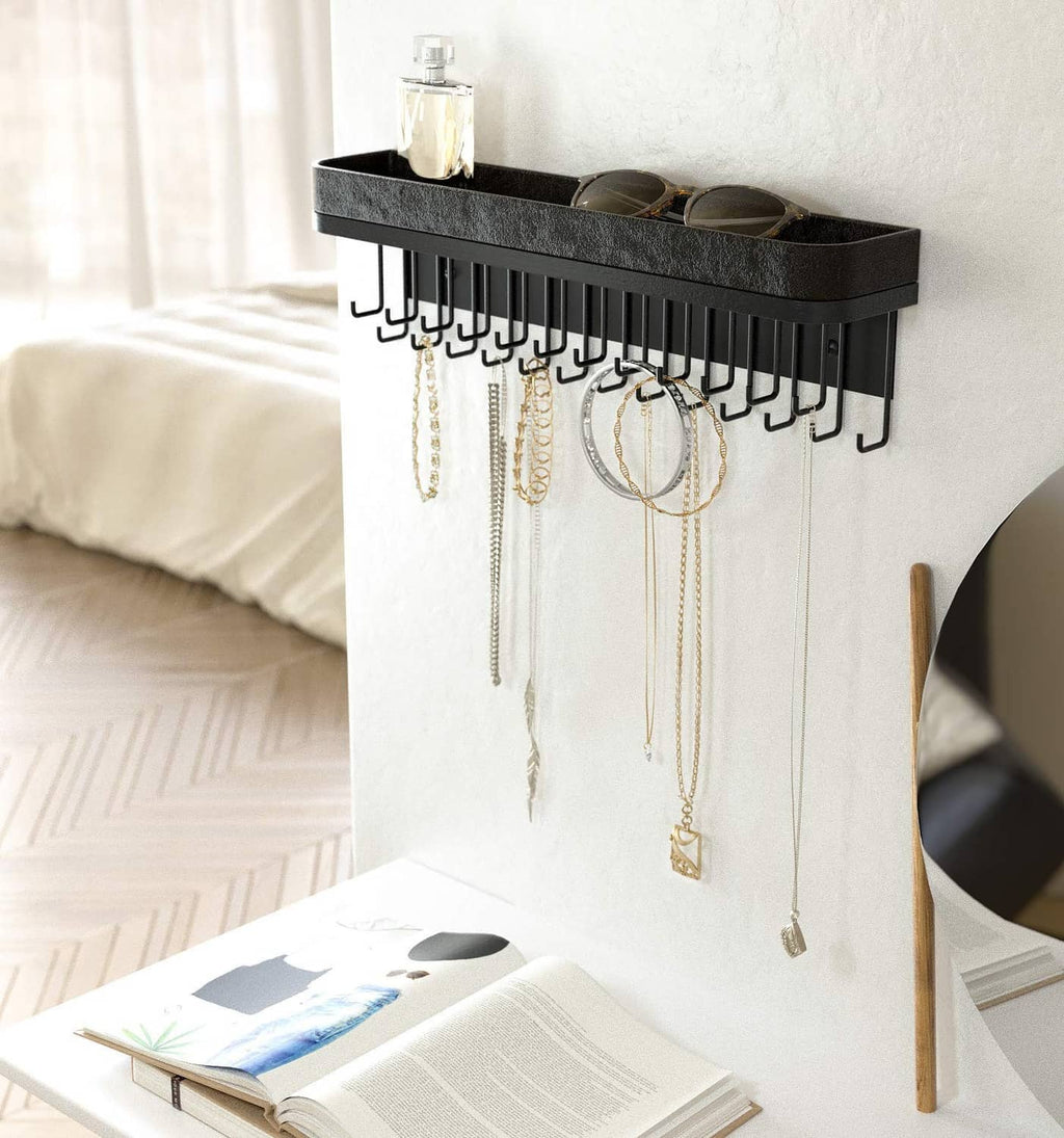 Black wall jewelry organizer with front necklace hooks and recessed top tray