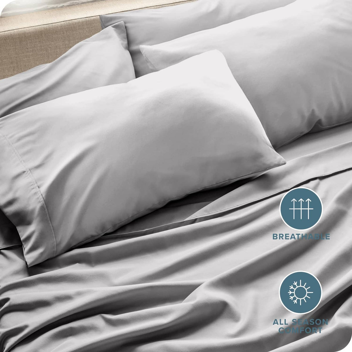 Light gray microfiber pillowcases with smooth envelope seams, layered on bed