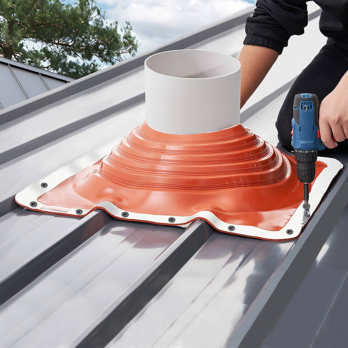 Orange silicone roof pipe flashing boot installed on metal roof with white pipe collar