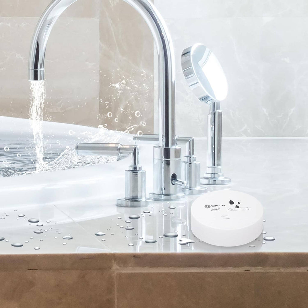 Three white water leak alarms near a bathroom sink with water droplets on units