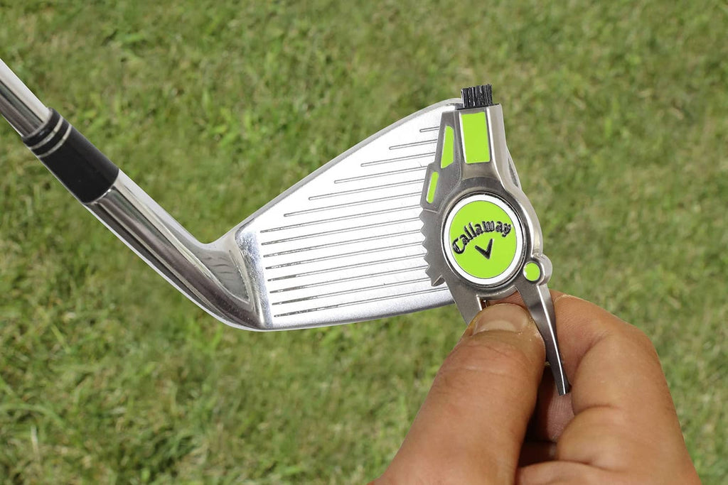 Hand using 4-in-1 golf divot repair tool on a golf club, lime details