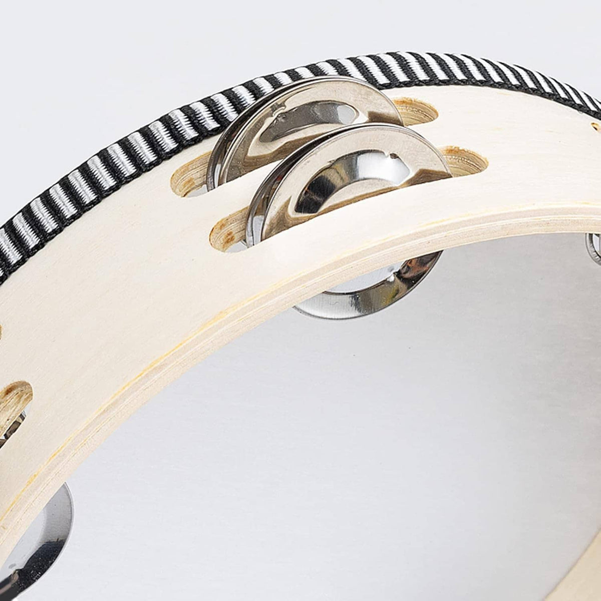 Close-up beige wooden tambourine with silver jingles and black-and-white striped rim