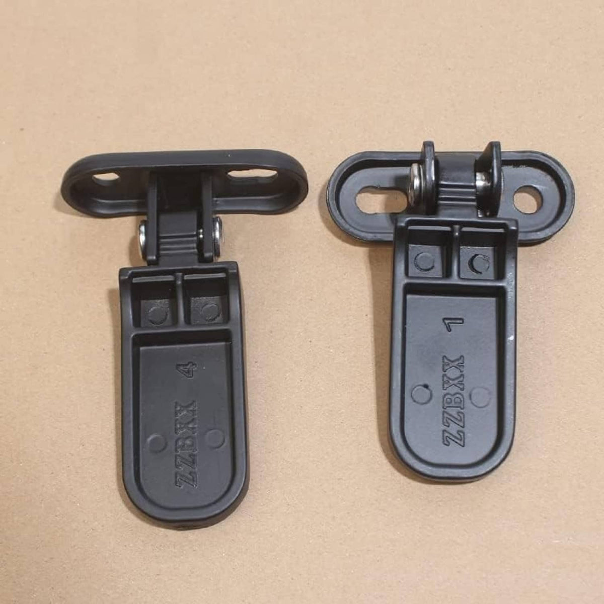 Black rear passenger footrest mounts with hinge hardware and textured tread
