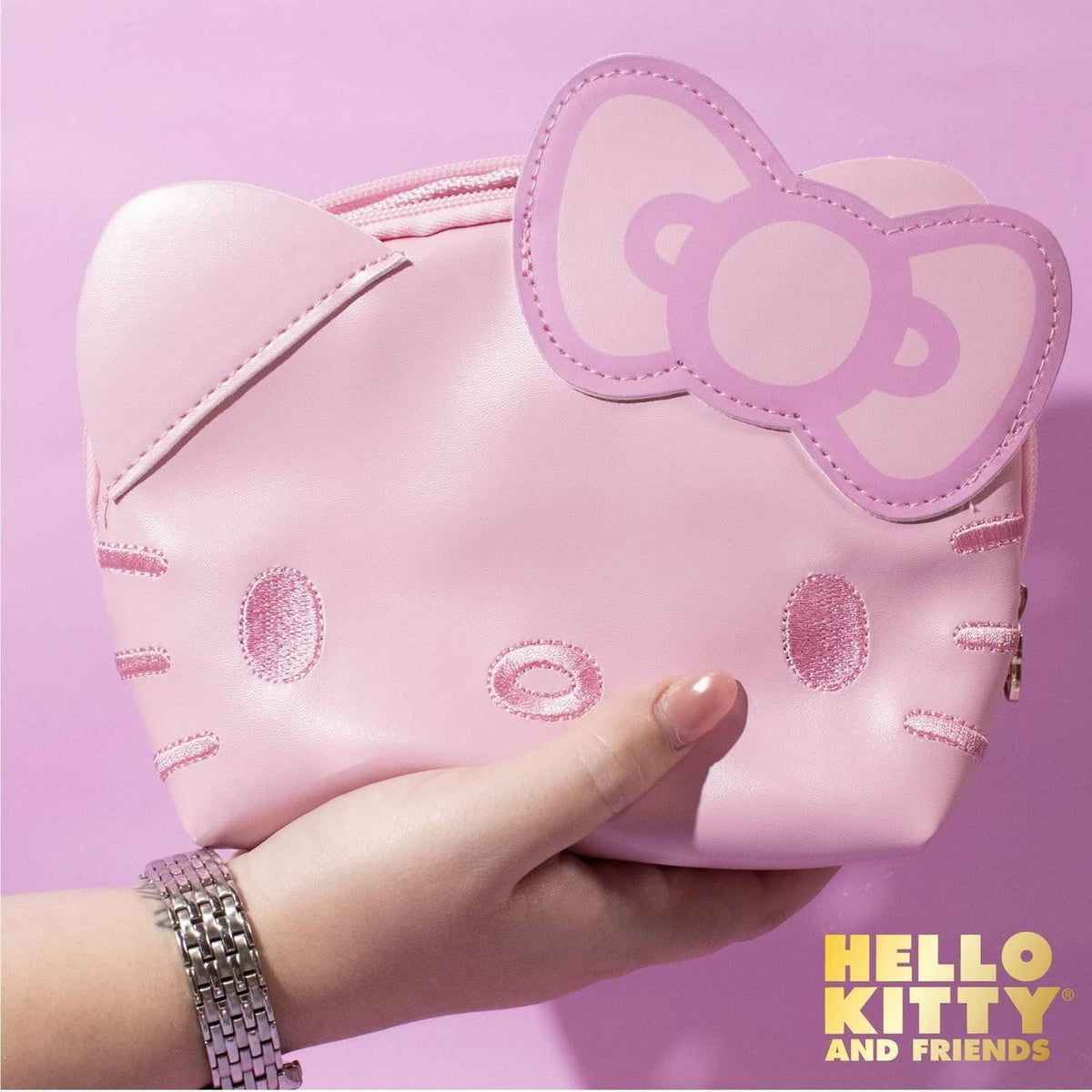 Pink Hello Kitty mini pouch with cat-ear flap and dotted stitched pattern, close-up