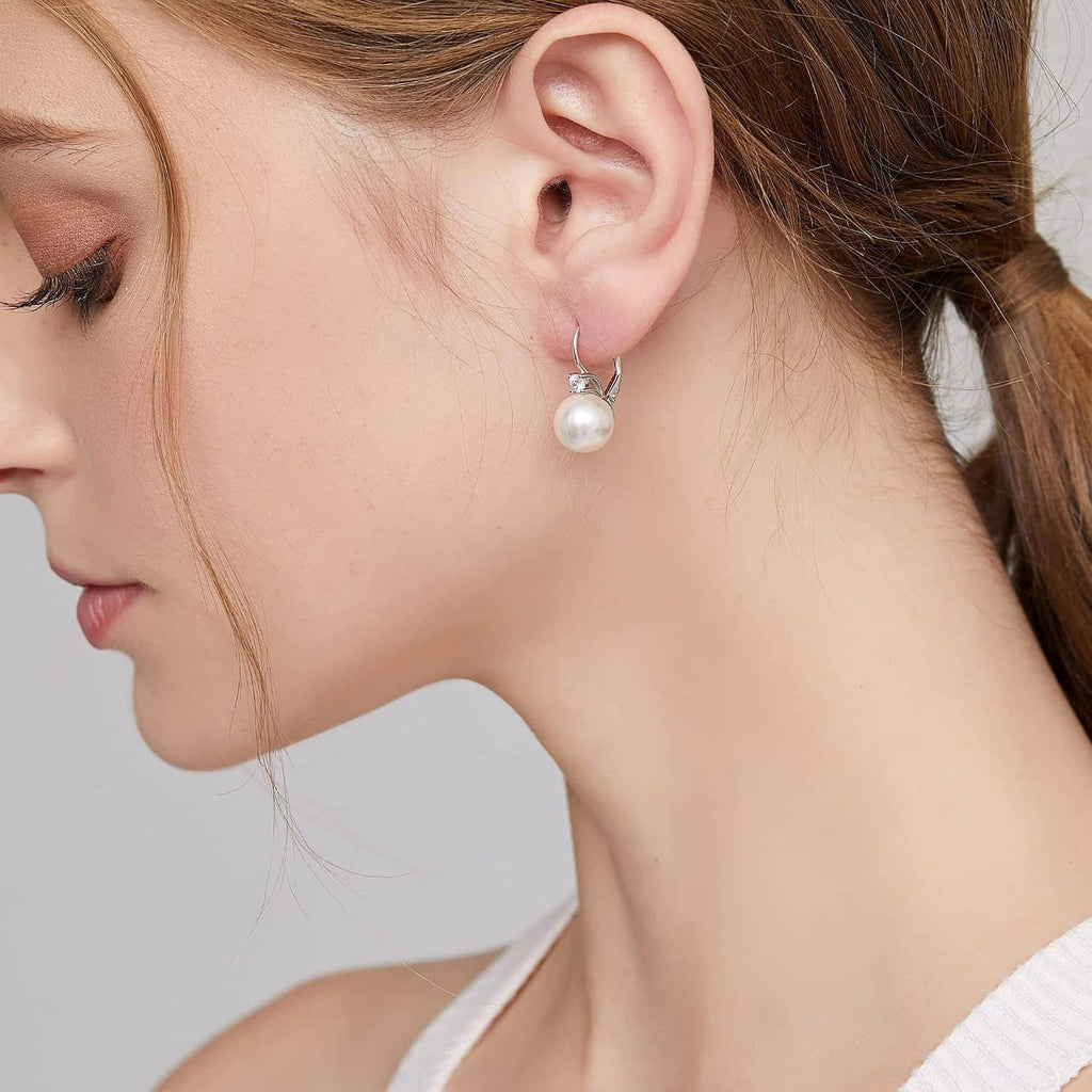 Sterling silver pearl leverback earrings on model, round white pearl dangle with crystal top