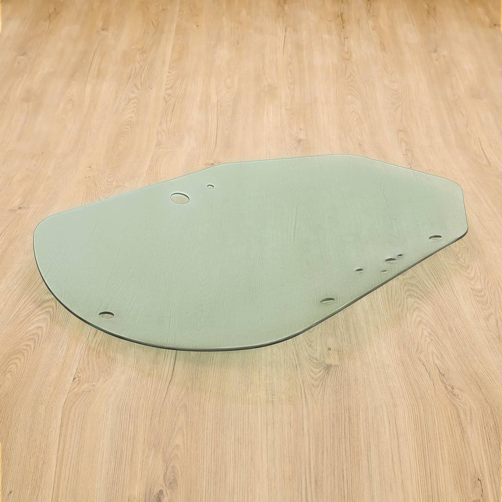 Light green cab door glass for skid steer with mounting holes along corners