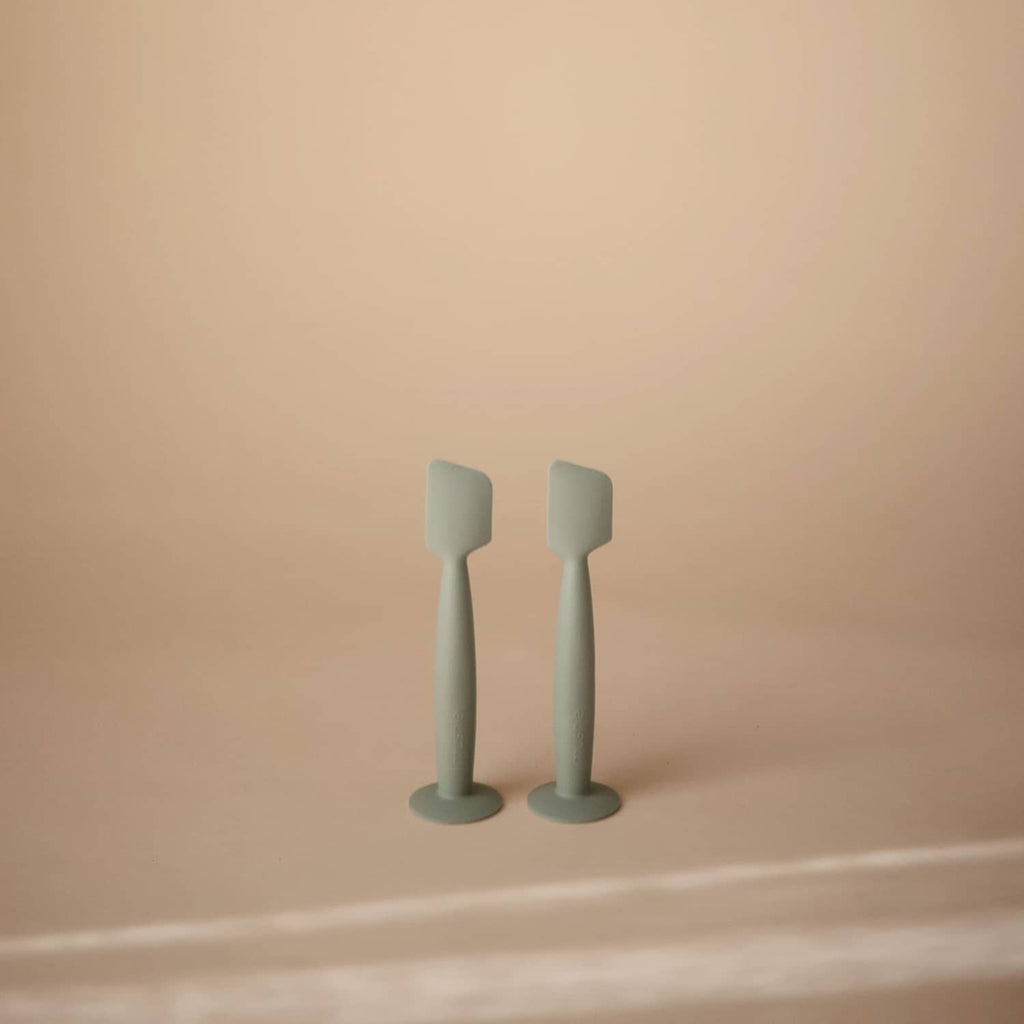 Set of two Mushie soft silicone diaper cream applicators with suction bases