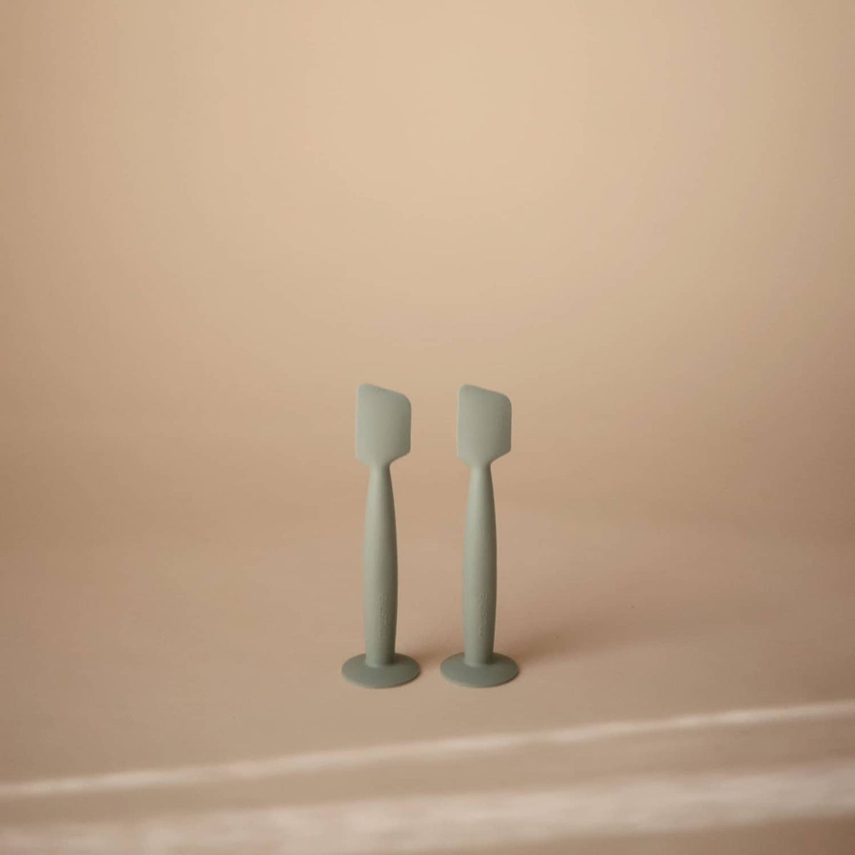 Set of two Mushie soft silicone diaper cream applicators with suction bases