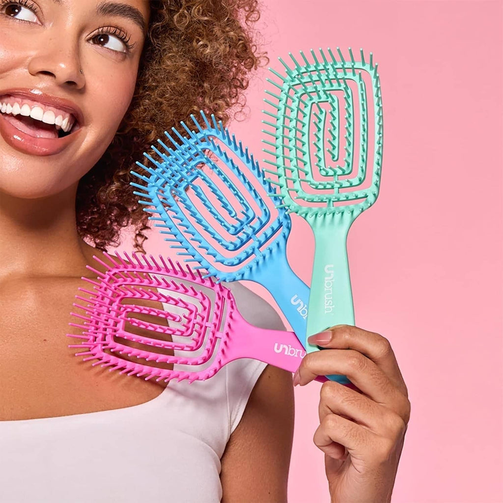 Teal detangling hairbrush brushing curly hair, flexible cushion bristles on handle
