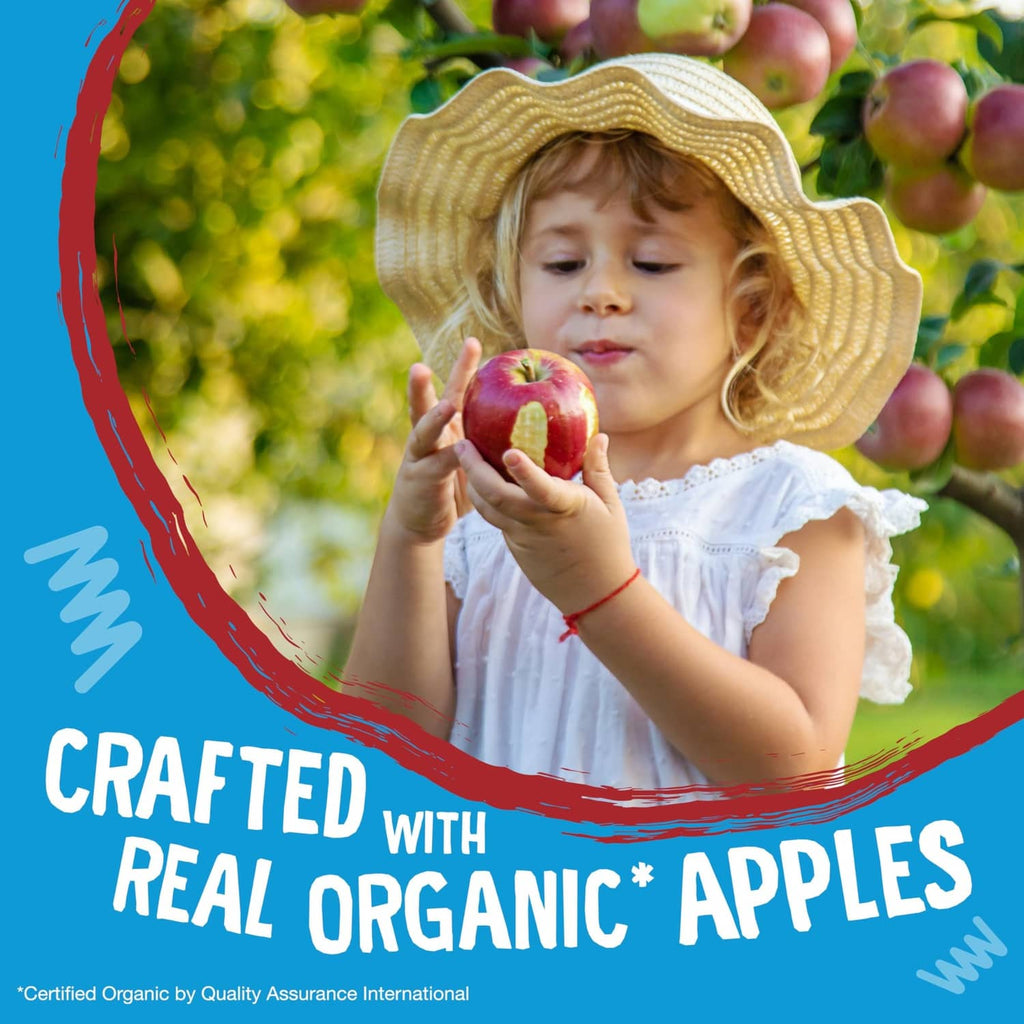 Child holding an apple outdoors with organic apples snack bar theme.