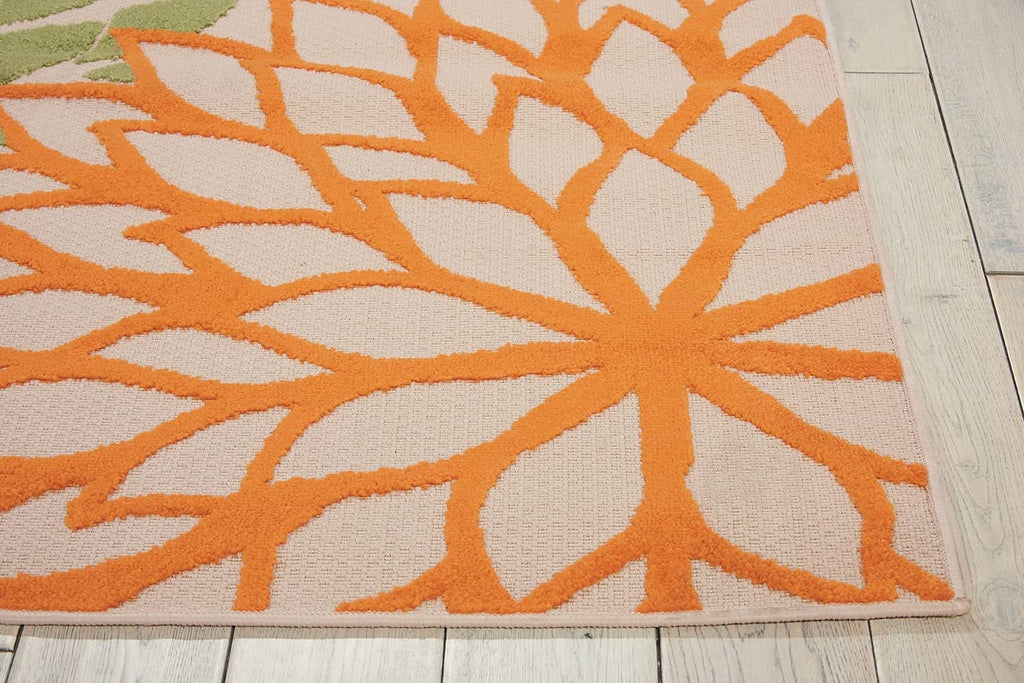 Tropical area rug corner detail with orange floral burst on off-white background