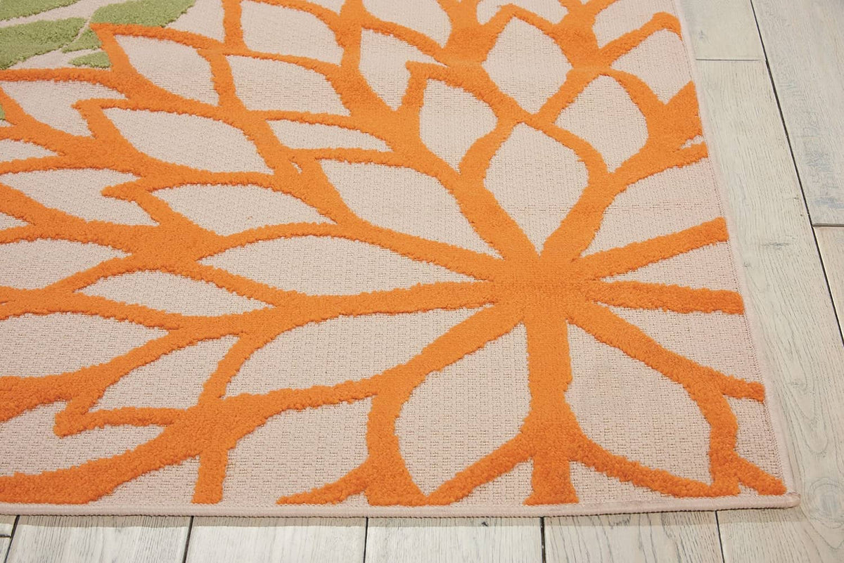 Tropical area rug corner detail with orange floral burst on off-white background