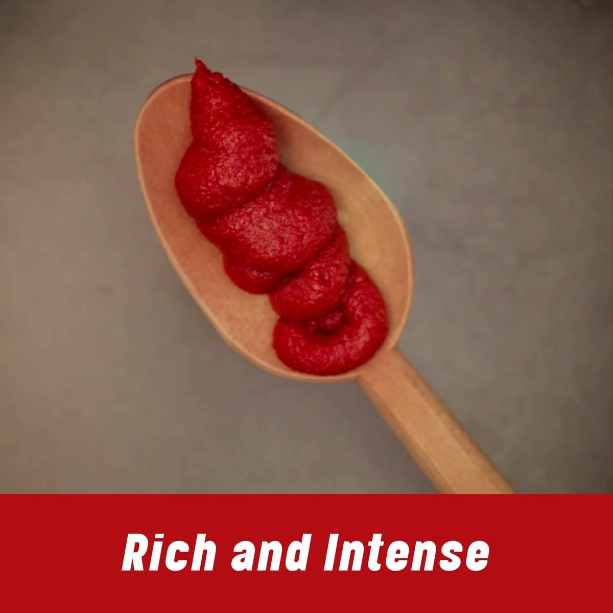 Wooden spoon filled with thick red tomato paste