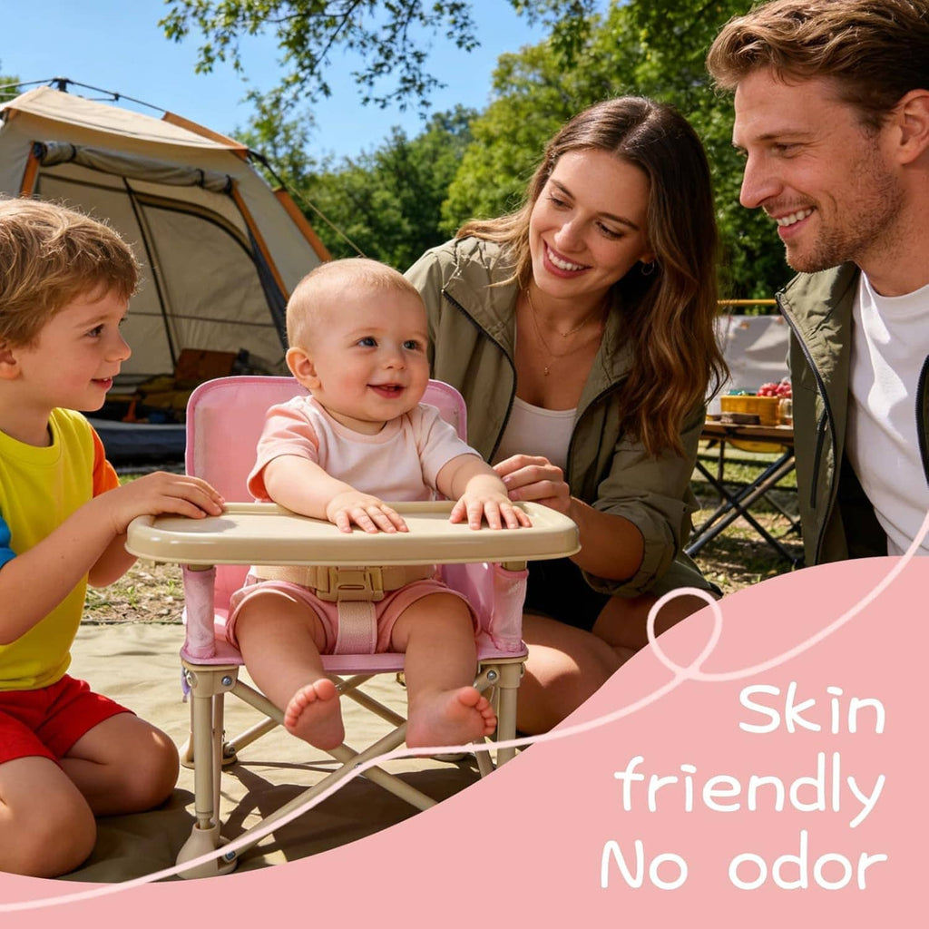 Pink portable baby booster chair with cream tray, toddler seated with family outdoors