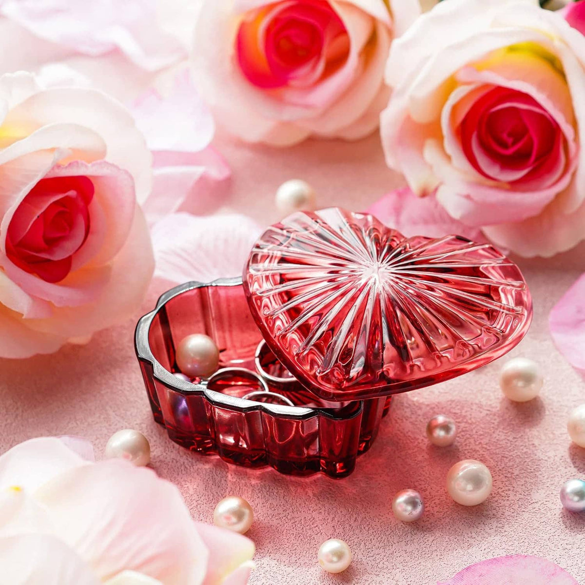Red heart-shaped crystal jewelry box with lid open, pearls inside