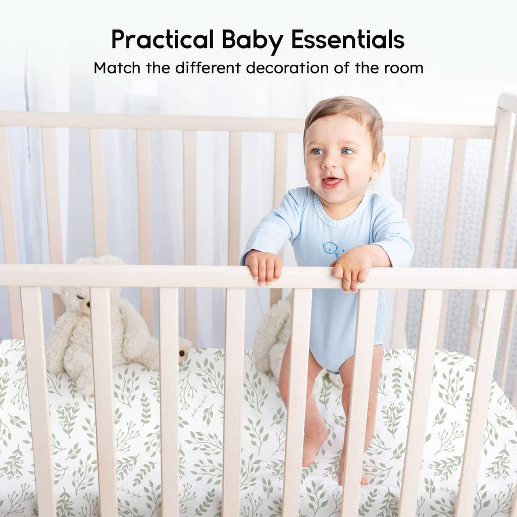 Fitted crib sheet with white leaf pattern and light green accents on a crib
