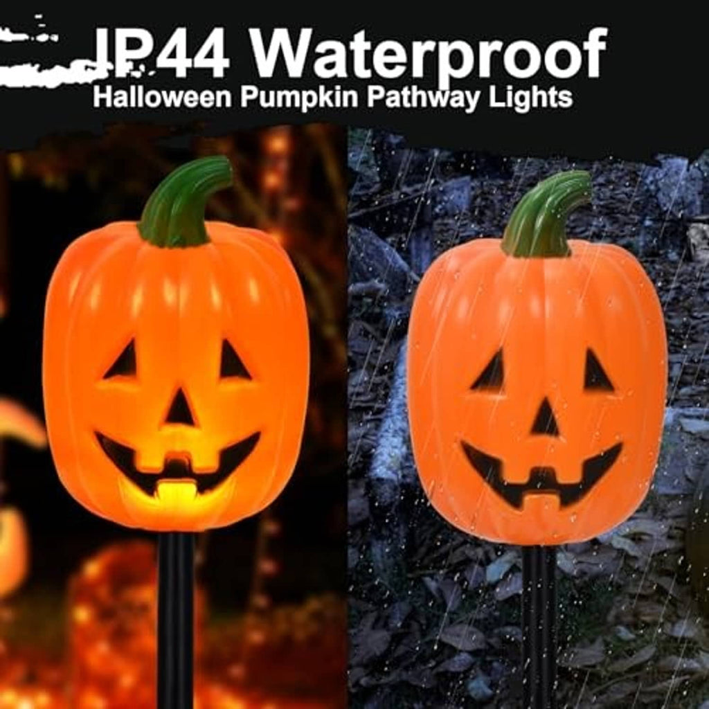 Jack-o'-lantern pumpkin stake lights with glowing faces, outdoor wet ground