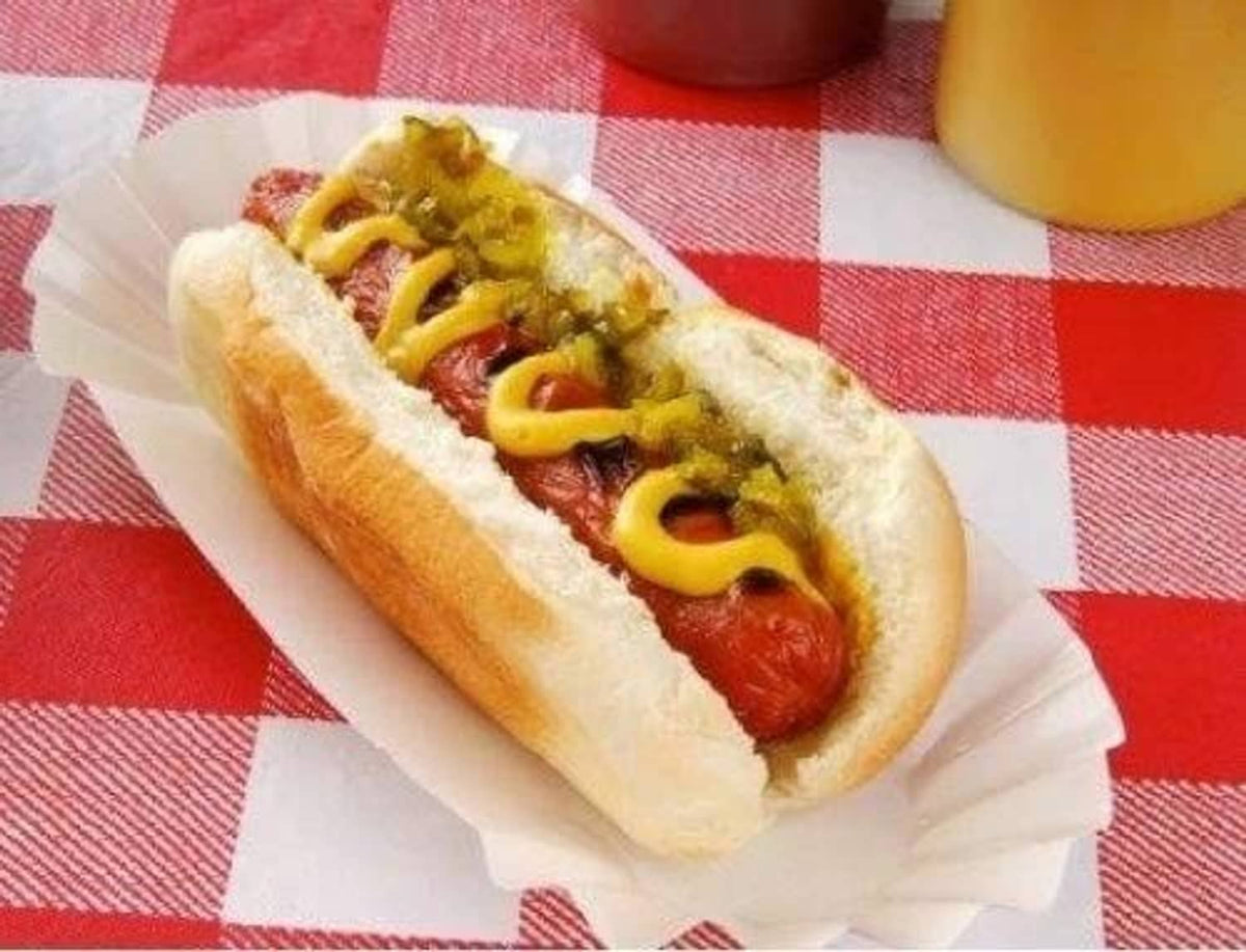 White paper hot dog tray with hot dog and sauce, crimped edges