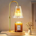 Luxmore candle warmer lamp with amber-gold arched metal frame, fluted glass shade, on wood base