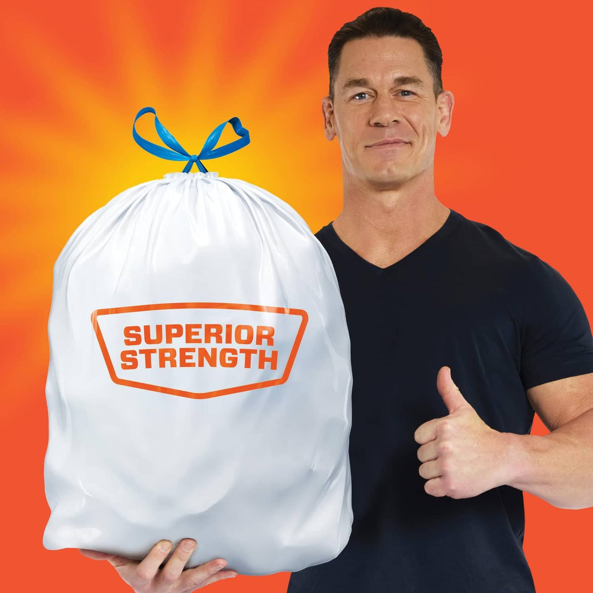 Hefty drawstring trash bag with bow, held by person; superior strength branding