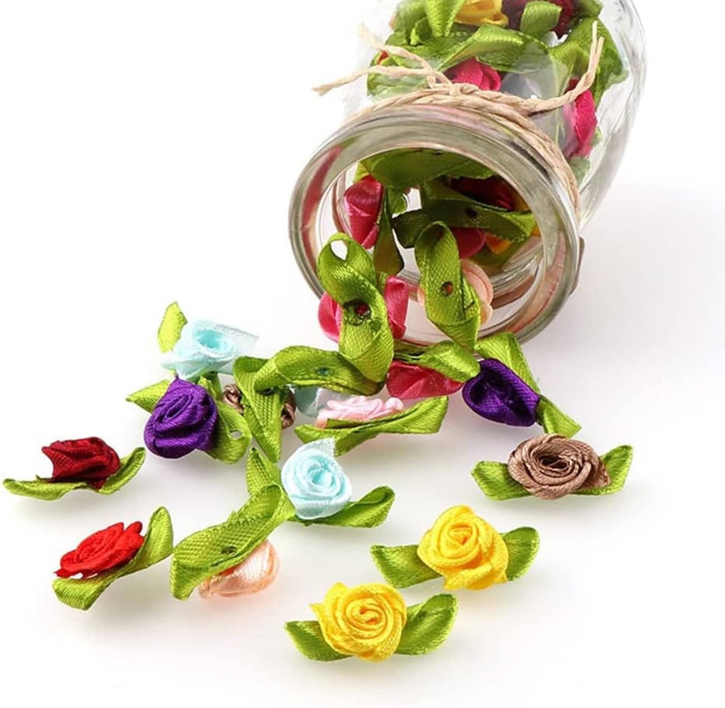 Mini ribbon rose flowers with green leaves spilling from a clear jar