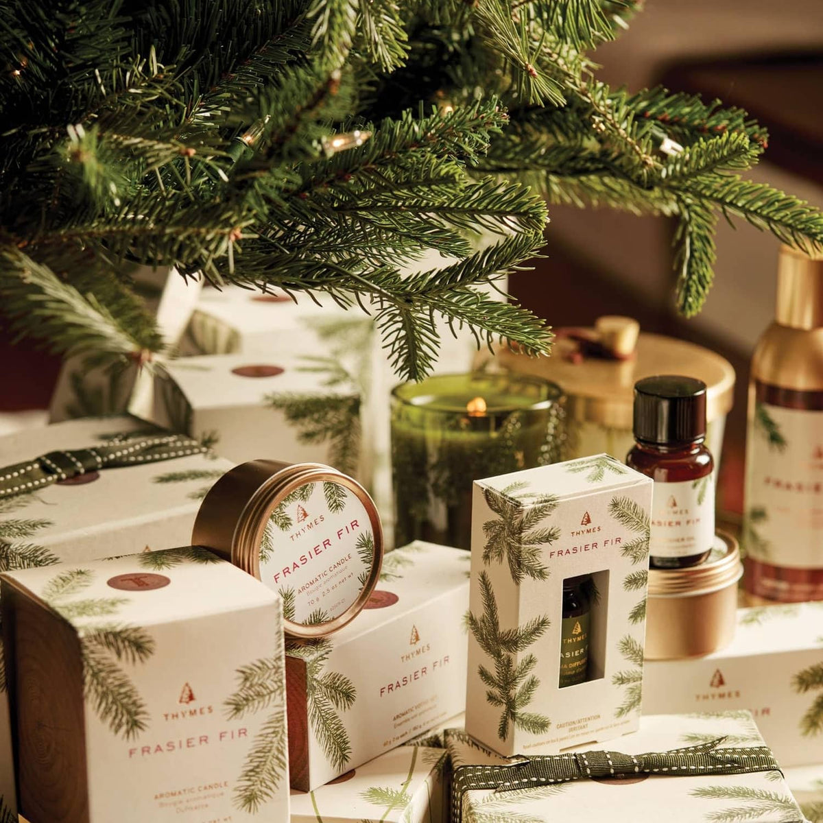 Frasier Fir candle gift set with wrapped packages and candle tins near pine branches