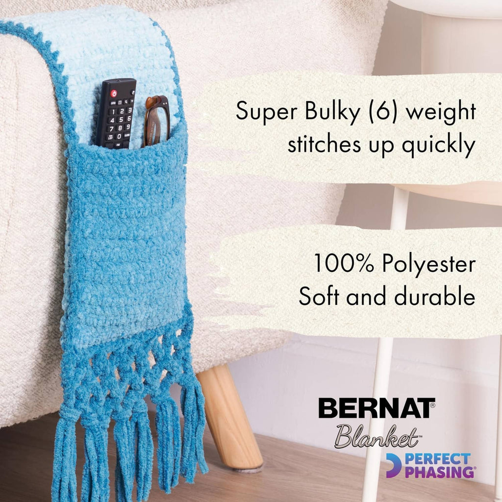 Super bulky crocheted throw blanket in light blue with long hanging fringe