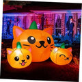 Orange inflatable cat-head trio with three green cone hats, pumpkin-style Halloween yard decor