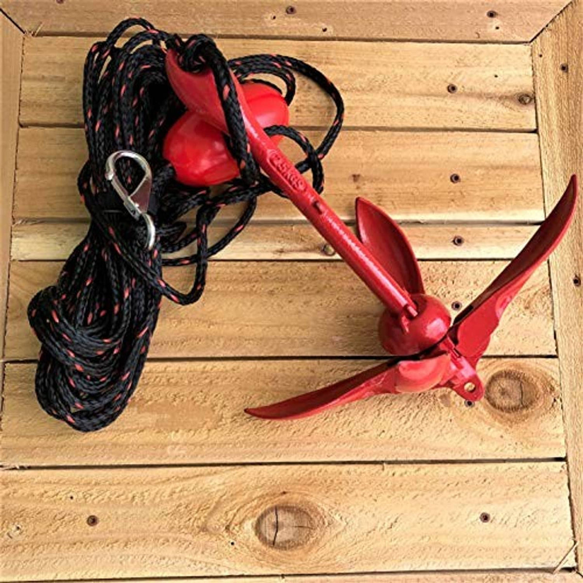 Grapnel anchor system shown with red anchor, black rope, and looped carabiner clips