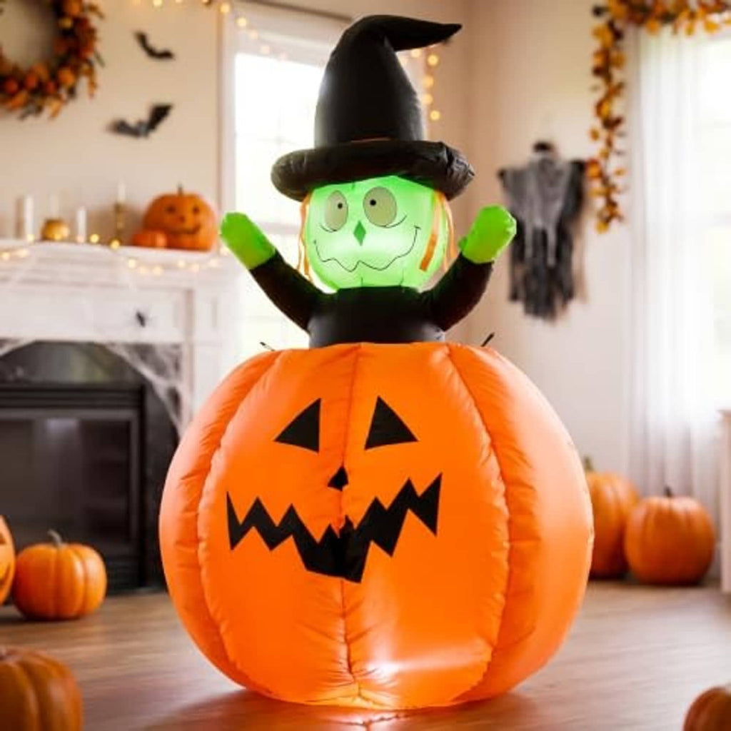 Halloween inflatable pumpkin witch decoration indoors, orange jack-o-lantern body with green face