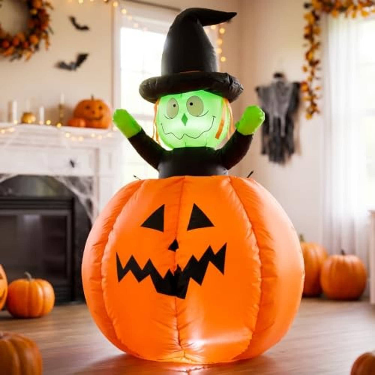 Halloween inflatable pumpkin witch decoration indoors, orange jack-o-lantern body with green face