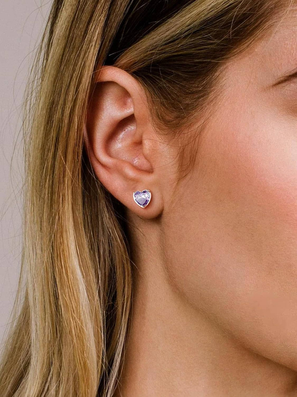 Purple heart stud earrings in 925 sterling silver on a woman’s ear