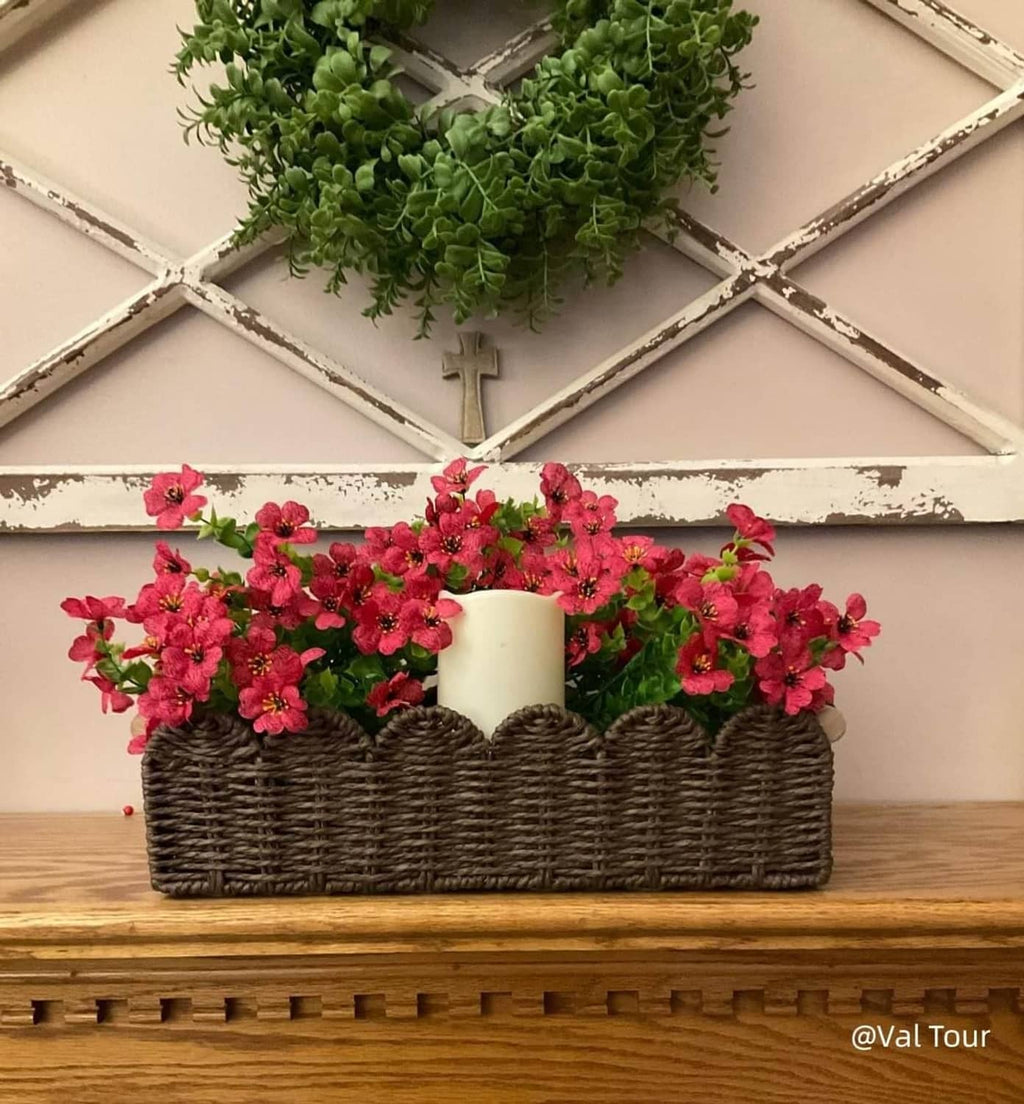 Dark brown woven basket with scalloped rim holding pink flowers