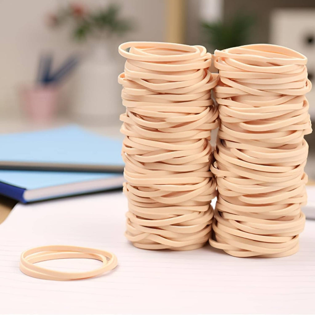 Beige elastic rubber bands in two tall stacks with one ring lying on top