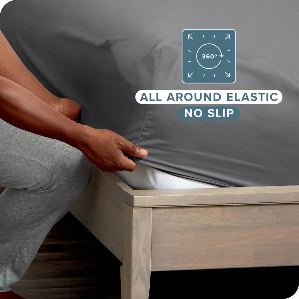 Grey fitted sheet corner with all-around elastic, elastic edge held by hand