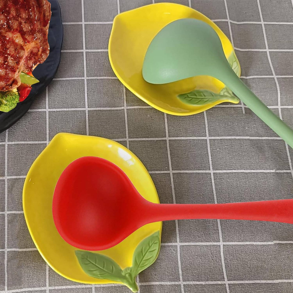 Yellow ceramic lemon-shaped spoon rest with green leaf sides and light green spoon