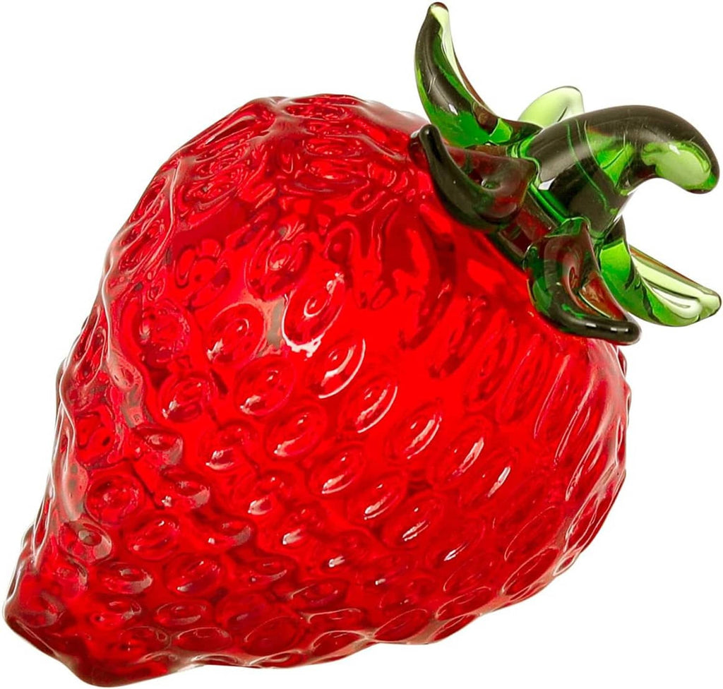Close-up red glass strawberry figurine with raised green leaves, glossy details