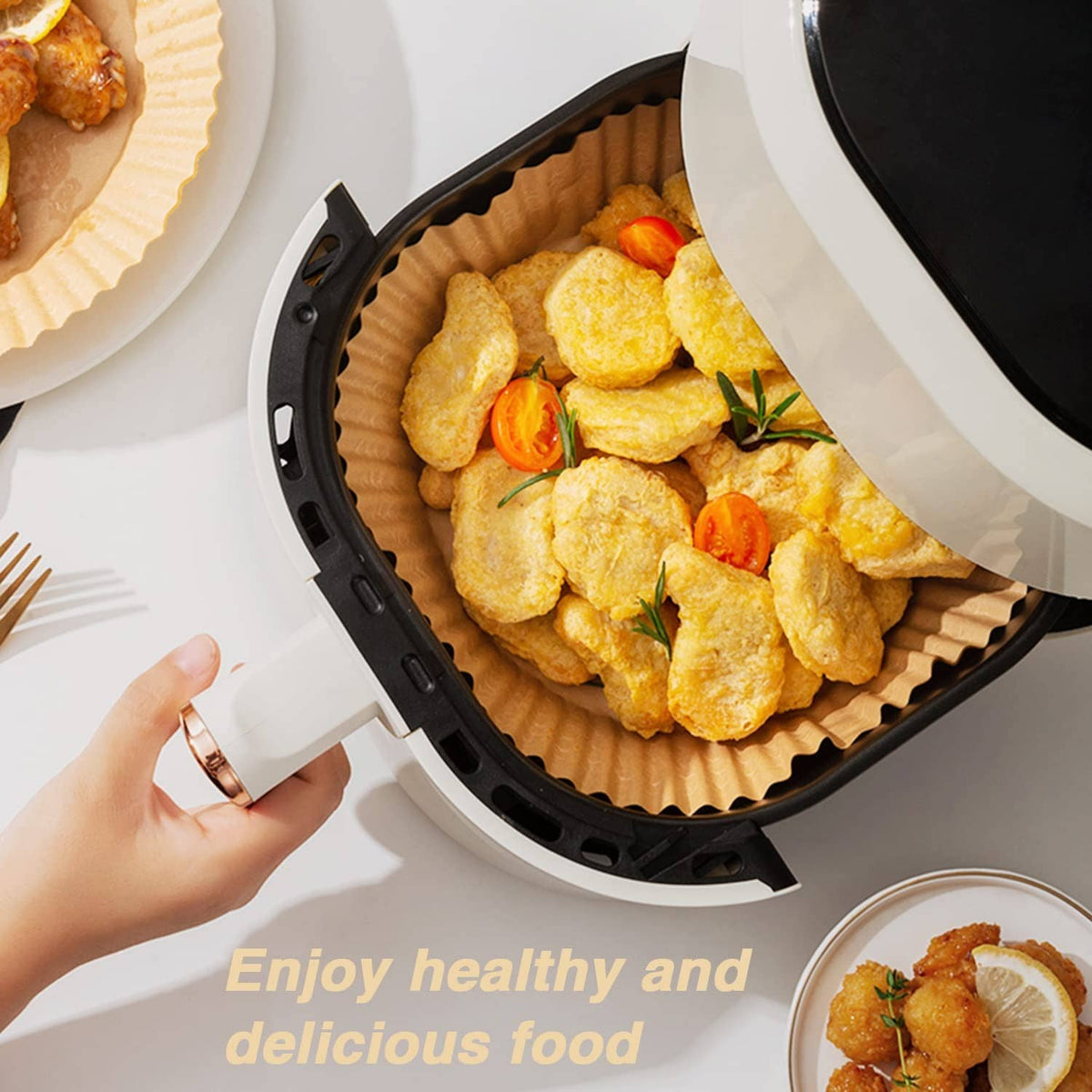 Brown paper liner in air fryer with breaded pieces and vegetables ready to cook.