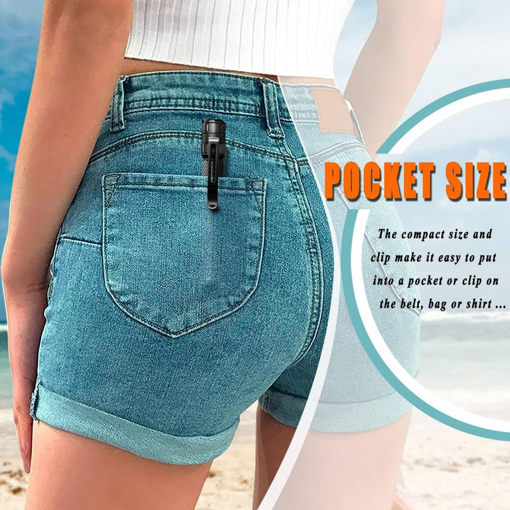 Pocket-size black mini LED flashlight pen clipped to blue denim pants, compact and portable.