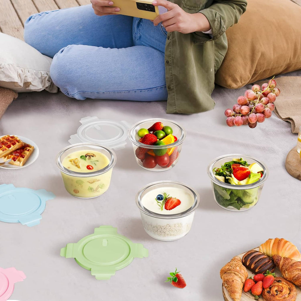 Assorted glass meal prep containers with airtight lids on a table with food portions.